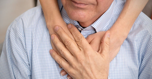 senior with daughters hands around him 