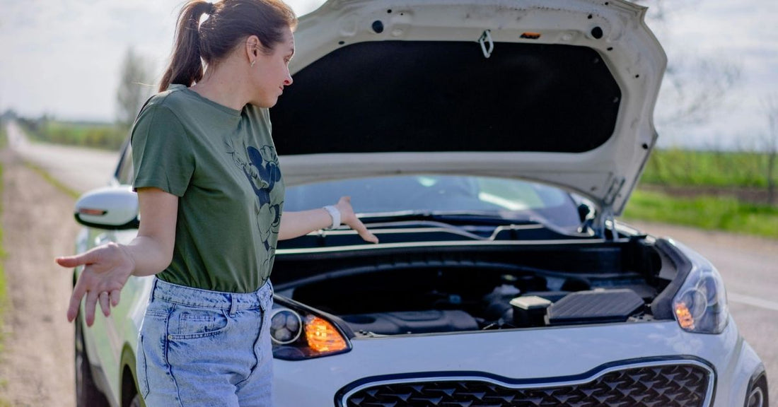 girl looking at open hood on her broken down car and shrugging her shoulders