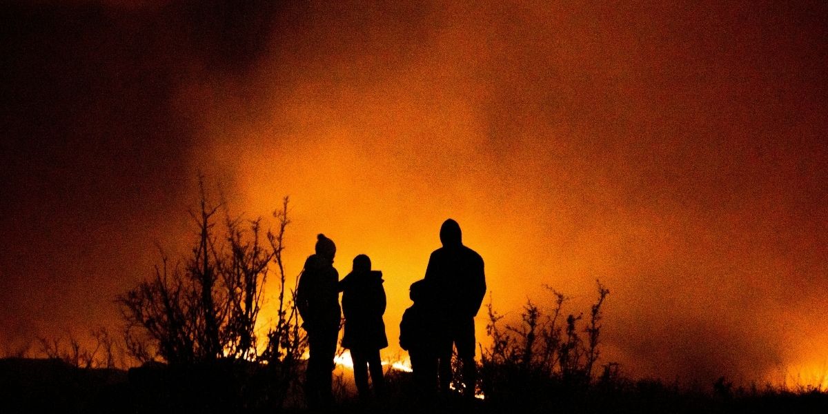 Family with packed emergency go bags preparing to evacuate ahead of a wildfire
