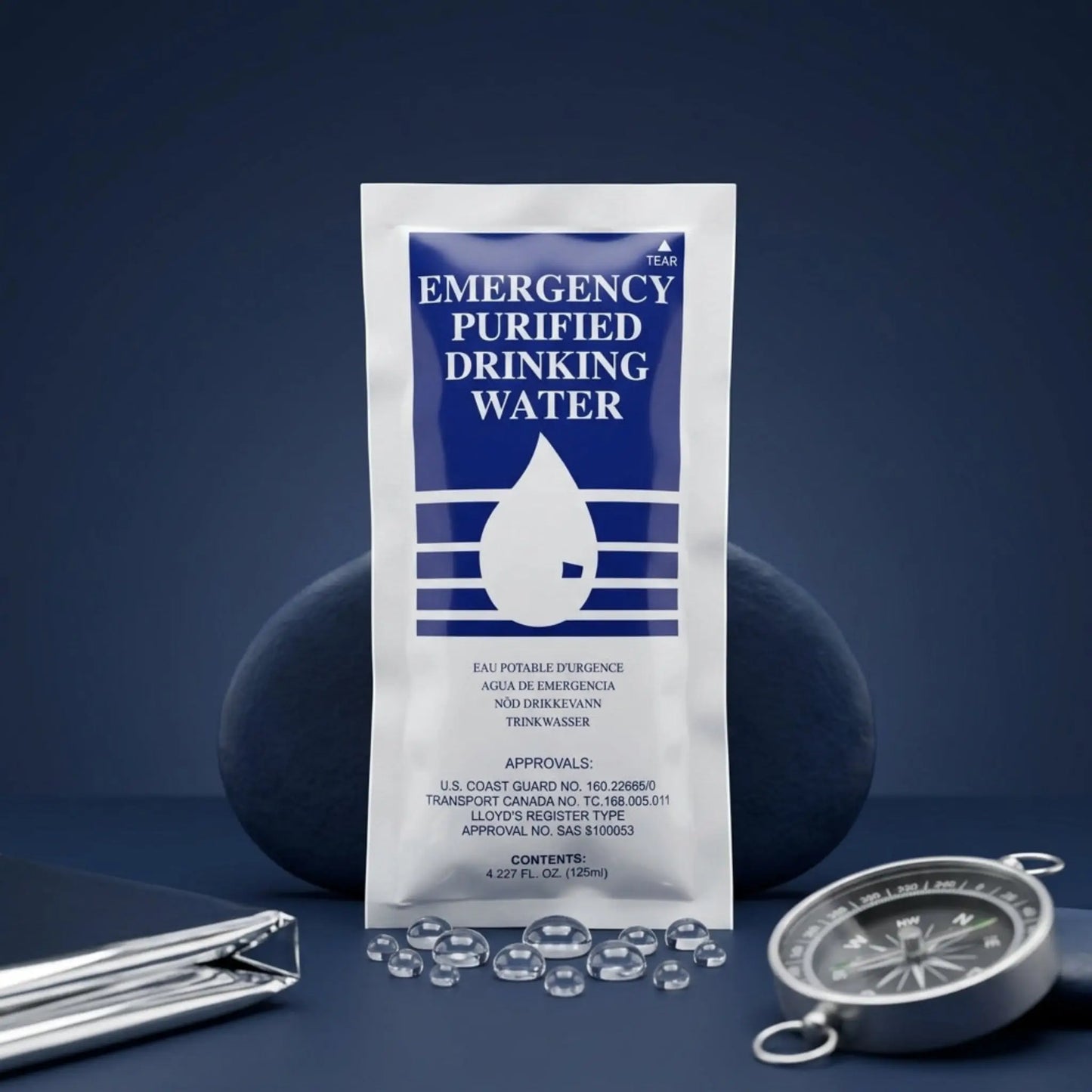 Emergency purified drinking water pouch standing upright on a dark blue surface, with a compass in the foreground.