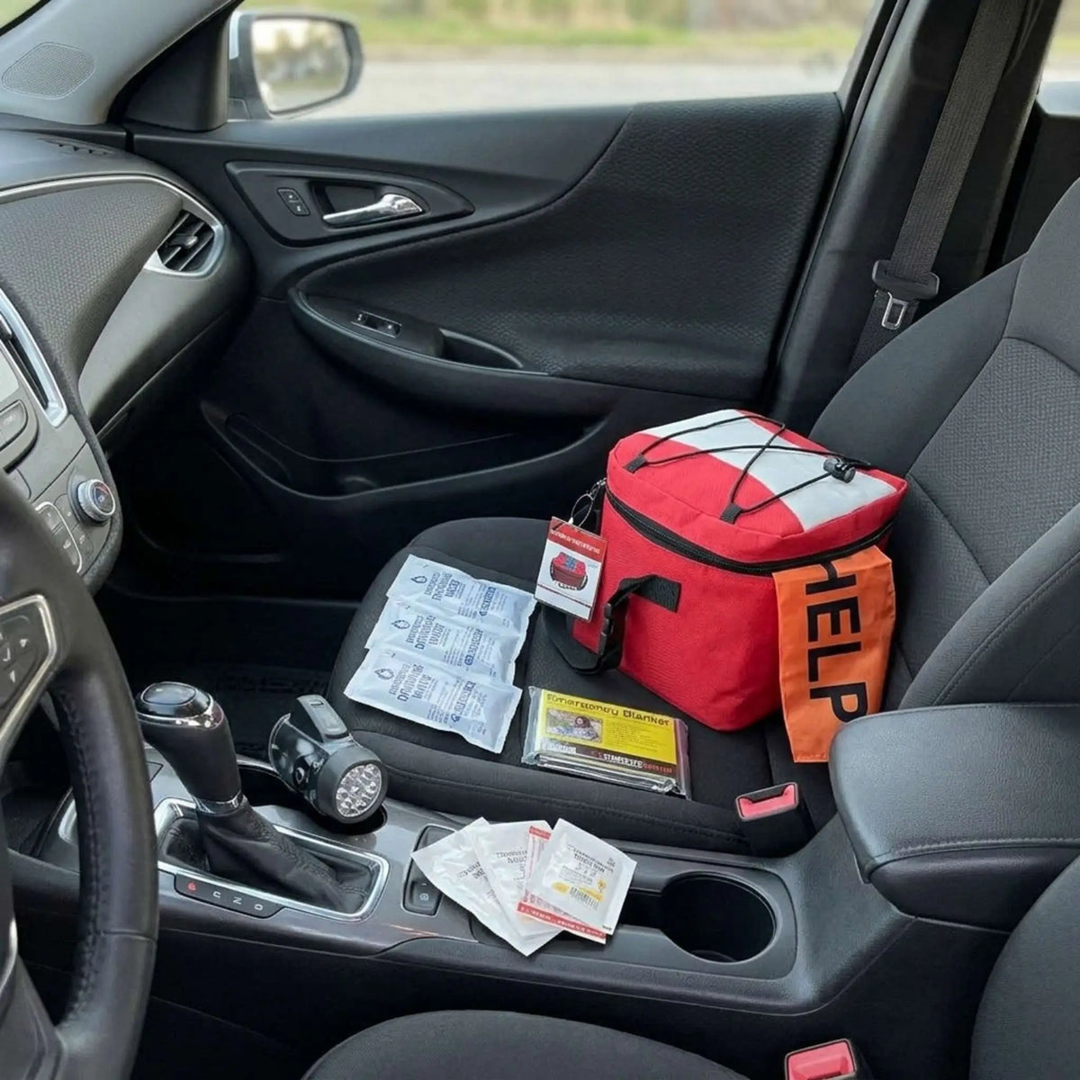 car emergency kit on front passenger seat of car with contents displayed