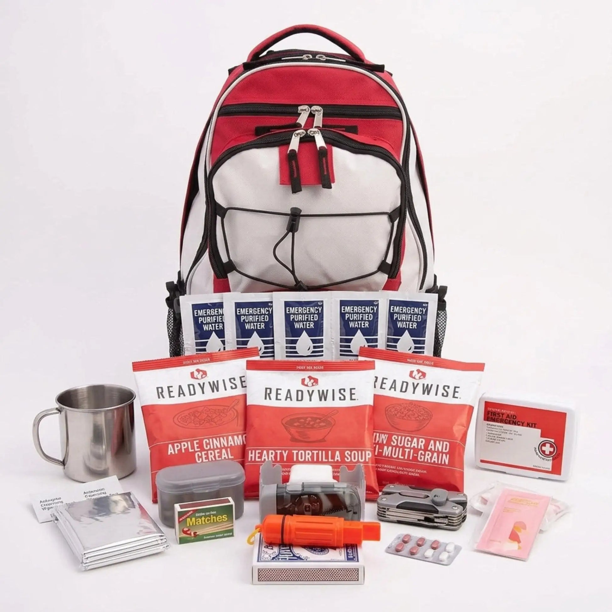 A red, white, and black backpack shown with an assortment of emergency preparedness items arranged in front on a white studio background. The kit includes ReadyWise snack packs, emergency water packets, a metal cup, a small container, blister packs, and other survival/travel accessories.